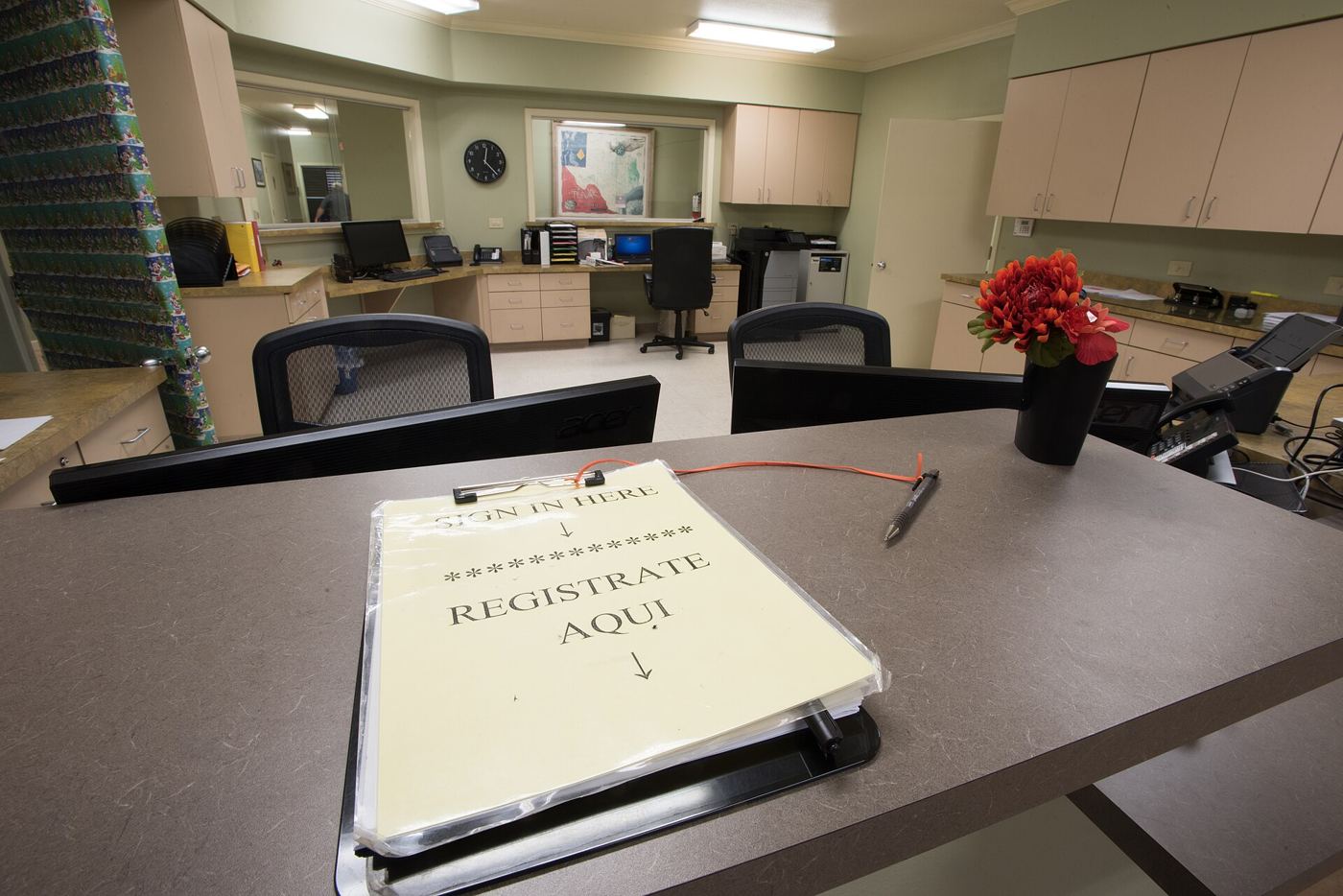 Patients sit in a bright community clinic waiting room before their appointments.